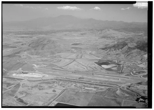  WEST DAM, LOOKING EAST; NOTE FOREBAY AND PUMP HOUSE UNDER CONSTRUCTION AT LOWER LEFT, NEW WATER SUPPLY CANAL CUTTING ACROSS LOWER THIRD OF PICTURE SPACE. - Eastside Reservoir, Diamond & Domenigoni Valleys, southwest of Hemet, Hemet, Riverside County, CA