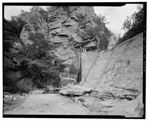  OBLIQUE VIEW TO NORTHEAST ALONG FRONT OF SANTA ANA RIVER DIVERSION DAM. NOTE CABLE CAR SUSPENSION CABLE AT GATE ATOP DAM. - Santa Ana River Hydroelectric System, Santa Ana River Diversion Dam, Redlands, San Bernardino County, CA