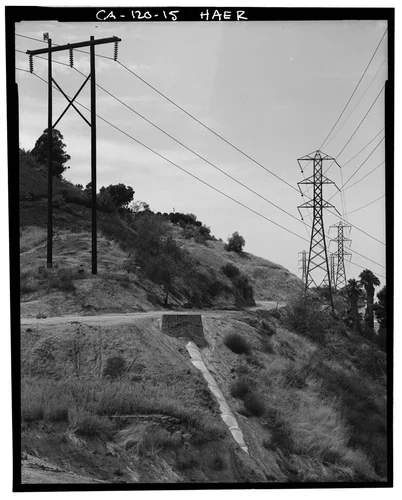  VIEW OF GAGE IRRIGATION CANAL NEAR HILLTOP DRIVE AND BARTON ROAD, SHOWING END OF SIPHON. CANAL FOLLOWS CONTOUR OF HILL UNDER DIRT ROAD - Gage Irrigation Canal, Running from Santa Ana River to Arlington Heights, Riverside, Riverside County, CA