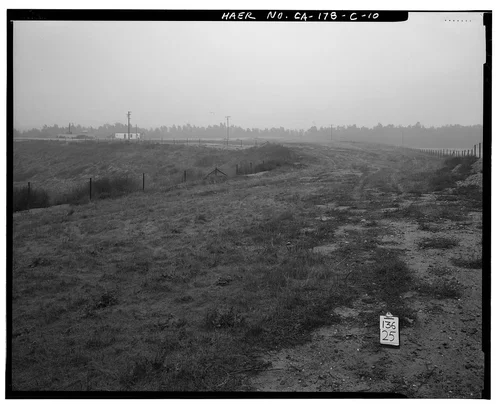  VIEW TO NORTHEAST ALONG NORTHWEST SPILLWAY ABUTMENT; SERVICE VEHICLE GARAGE IN BACKGROUND. - Prado Dam, Spillway, Santa Ana River near junction of State Highways 71 & 91, Corona, Riverside County, CA