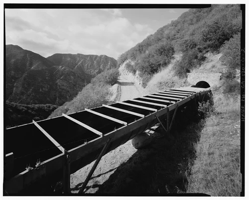  OVERVIEW OF MAINTENANCE ROAD AND FOURTH FLUME ABOVE SAR-1 FOREBAY, HIGH ABOVE SANTA ANA RIVER BED, LOOKING SOUTHWEST. - Santa Ana River Hydroelectric System, Flumes & Tunnels below Sandbox, Redlands, San Bernardino County, CA
