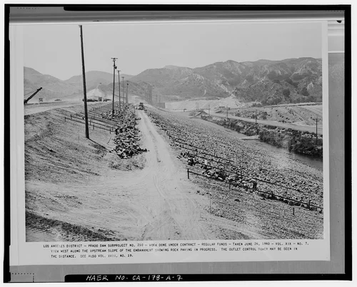  VIEW WEST ALONG THE UPSTREAM SLOPE OF THE EMBANKMENT, SHOWING ROCK PAVING IN PROGRESS.... Volume XIX, No. 7, June 24, 1940. - Prado Dam, Embankment, Santa Ana River near junction of State Highways 71 & 91, Corona, Riverside County, CA