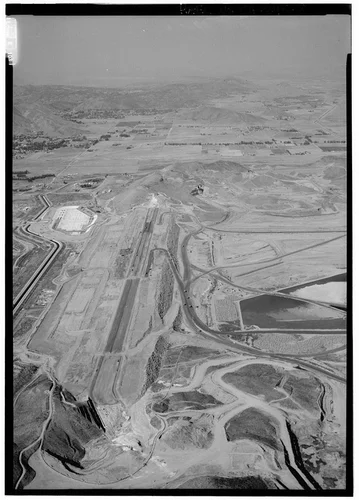  WEST DAM, LOOKING DUE NORTH OVER TOP OF WEST DAM, SHOWING RELATIONSHIP BETWEEN OUTLET TO RIGHT OF DAM, NEW PUMP PLANT BUILDING AND CANAL TO LEFT OF DAM. - Eastside Reservoir, Diamond & Domenigoni Valleys, southwest of Hemet, Hemet, Riverside County, CA