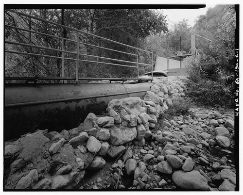  FIRST SECTION OF PIPELINE BETWEEN CONFLUENCE POOL AND FISH SCREEN. NOTE RETAINING WALL BESIDE PIPE. VIEW TO NORTH-NORTHEAST. - Santa Ana River Hydroelectric System, Pipeline to Fish Screen, Redlands, San Bernardino County, CA
