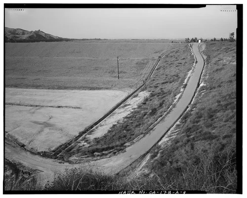  DRAINAGE CHANNEL AND ACCESS ROAD AT EAST END OF EARTH EMBANKMENT, LOOKING NORTH. - Prado Dam, Embankment, Santa Ana River near junction of State Highways 71 & 91, Corona, Riverside County, CA