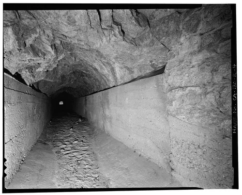  INTERIOR OF ABANDONED SANTA ANA CANAL TUNNEL, SHOWING CEMENT TROUGH FLOOR AND UNFINISHED  GRANITE ROOF. VIEW TO SOUTHWEST. - Santa Ana River Hydroelectric System, Abandoned Tunnel, Redlands, San Bernardino County, CA