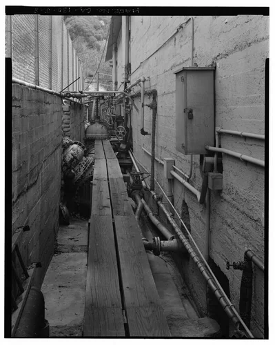  NORTHWEST PENSTOCK ENTERING RECEIVER (UNDER PLANKS), NORTHEAST SIDE OF SAR-1. VIEW TO SOUTHEAST. - Santa Ana River Hydroelectric System, SAR-1 Powerhouse, Redlands, San Bernardino County, CA