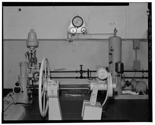  GENERATOR #1 NEEDLE VALVE CONTROL WHEEL, WATERWHEEL GOVERNOR, PENSTOCK PRESSURE GAUGE, AND GOVERNOR OIL SET.  VIEW TO EAST. - Santa Ana River Hydroelectric System, SAR-2 Powerhouse, Redlands, San Bernardino County, CA