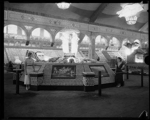Two women stand in front of the Riverside County display at the Los Angeles County Fair, Pomona, 1933
