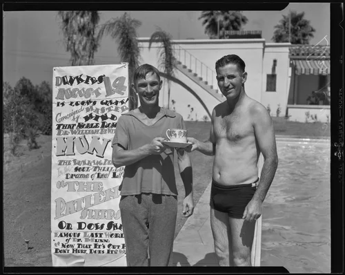 Eddie Peabody, at his home, receives a "Dunkers" club cup and saucer of initiation from club member Dan Huckins, Riverside, 1935