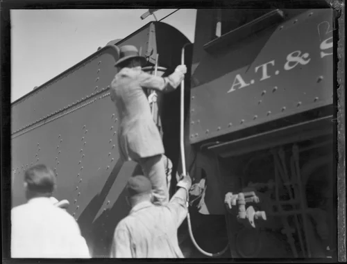 Crown Prince Gustav Adolf of Sweden clibing into in the cab, or engineer's compartment, of a train, [Los Angeles?], 1926
