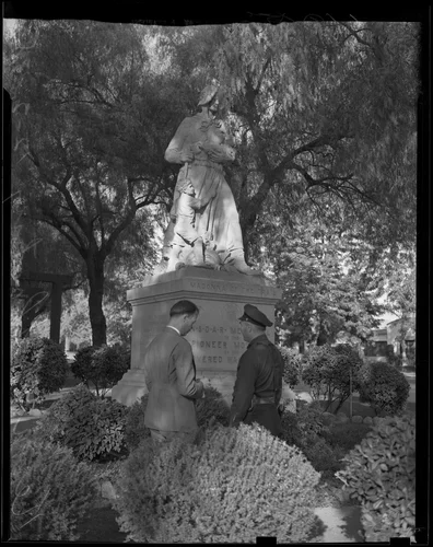Jack Kermott and a police officer stand in front of Madonna of the Trail, Upland, 1938