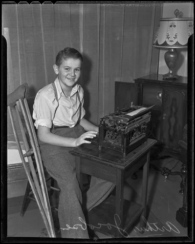 Edward Jacobsen sits at a typewriter and edits the school newspaper, Redlands, 1936
