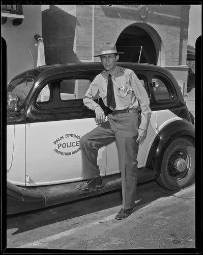 Police Chief C. W. Seaton leans on the new radio patrol car, Palm Springs, 1936