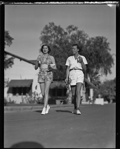 Lucy "Dickey Dell" Doheny and Joyce Hodgeson enjoy ice cream as they walk down a street, Palm Springs, 1936