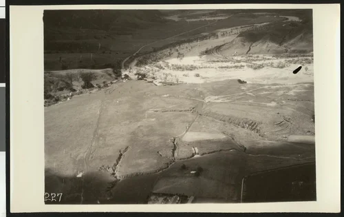 Aerial view of flooding of the Santa Ana River near Corona, showing flooding over a winding road, ca.1930