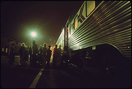 AMTRAK PASSENGERS BOARD THE SOUTHBOUND SAN DIEGAN AS IT MAKES A NIGHTTIME STOP AT THE FULLERTON, CALIFORNIA, STATION. AMTRAK CAME INTO BEING WITH THE RAILROAD PASSENGER SERVICE ACT OF 1970 WHICH AUTHORIZED THE NATIONAL RAILROAD PASSENGER CORPORATION TO MANAGE THE BASIC NATIONAL RAIL NETWORK AND OPERATE MOST U.S INTERCITY PASSENGER TRAINS UNDER CONTRACTS WITH THE NATION'S RAILROADS