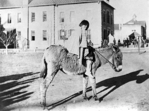 Child on burro at Santa Fe Indian School
